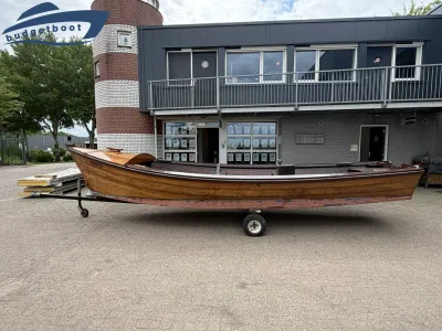 houten sloep op trailer voor gebouw