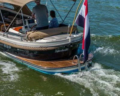 achterzijde van een open motorboot met vlag