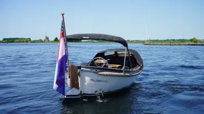 kleine open boot met vlag op rustig water
