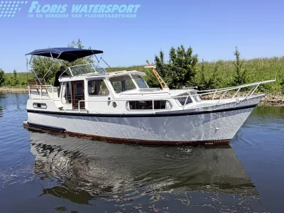 witte motorboot in kanaal bij oever