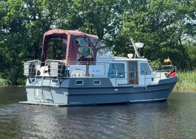 motorjacht op kanaal met bomen op achtergrond