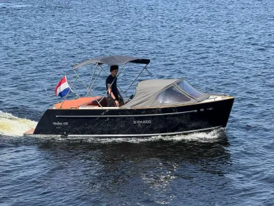 zwarte tender op open water met vlag
