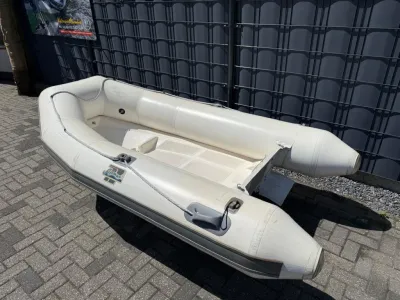 witte opblaasbare bijboot op bestrating