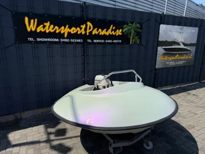 rond klein bootje op trailer bij winkelpand