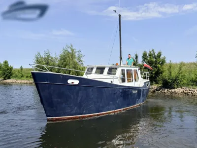 blauwe kotter op binnenwater bij oever