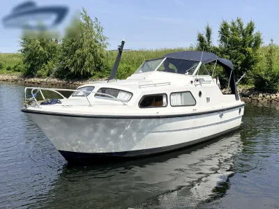 witte motorboot op het water met tent