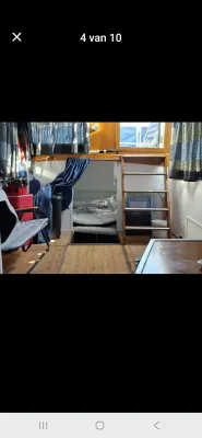 kajuitinterieur met bed, trap en gordijnen