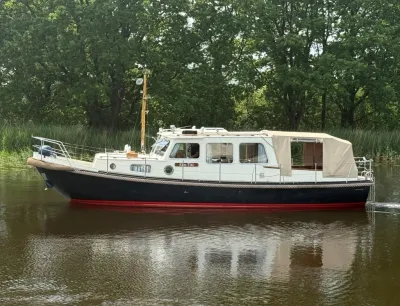 motorjacht op rustige rivier bij bomen