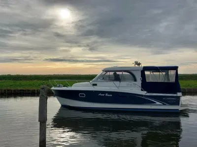 kajuitmotorjacht in kanaal bij bewolkte lucht