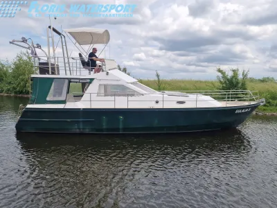 motorjacht afgemeerd op water met graswal
