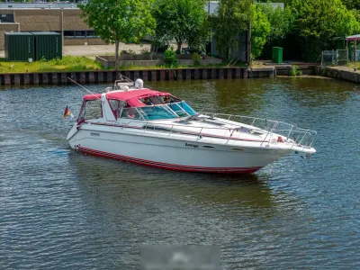 wit motorjacht met rood zonnedek op water