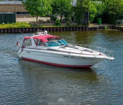 wit motorjacht met rood zonnedek op water