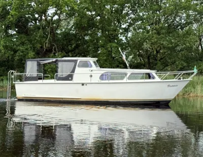 wit kruiser op water met bomen