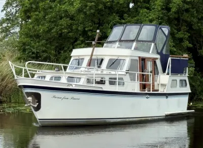 wit motorjacht bij bosrand