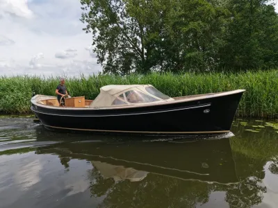 motorsloep in het riet bij bomen