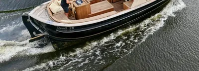 motorsloep varend in kanaal met gras oever