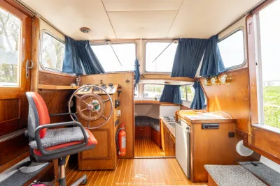 interieur van jacht met stuurstand en kombuis