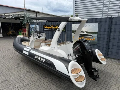 zwarte rib-boot op stenen kade bij showroom