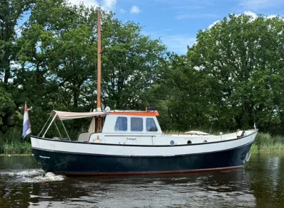 kotter op rustig water bij boomrijke oever