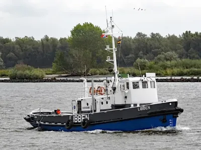 sleepboot op rivier bij oever