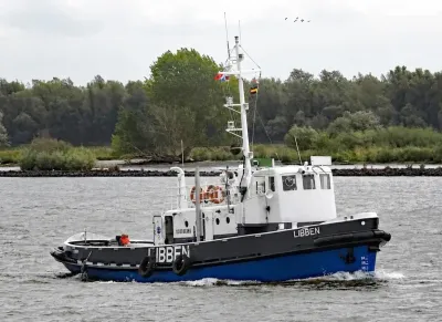 sleepboot op rivier bij oever