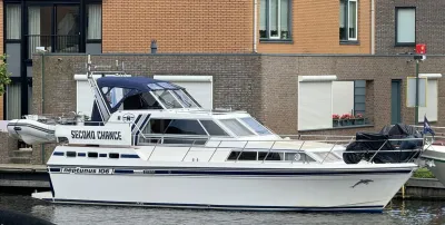 wit motorjacht aangemeerd bij kade