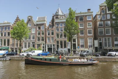 rondvaartboot op gracht met gebouwen op achtergrond