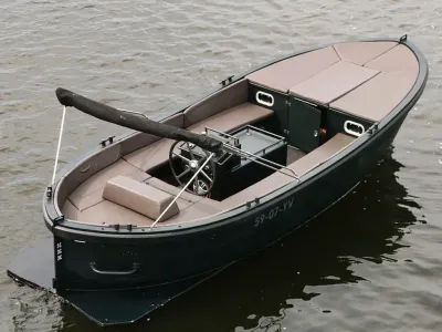 donkergroene sloep met kussens en stuurconsole