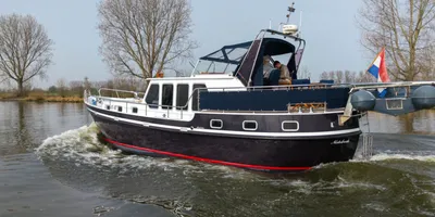 motorjacht op rivier bij kale bomen
