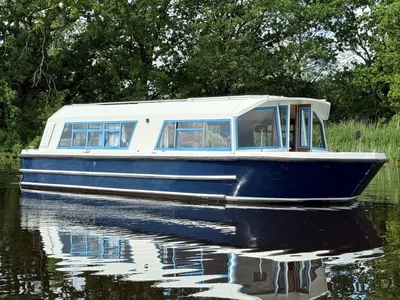 woonboot op rustig water bij bomen
