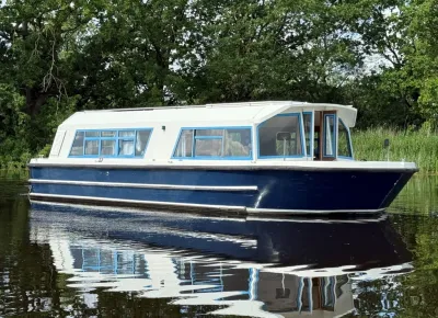 woonboot op rustig water bij bomen