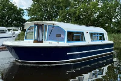 woonboot op water bij groene oever