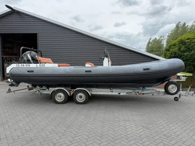 rubberboot op trailer bij schuur