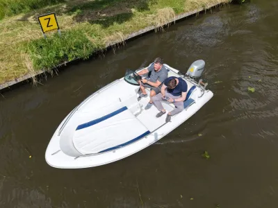 witte open motorboot met twee personen