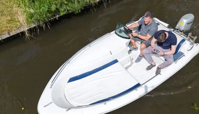 witte open motorboot met twee personen