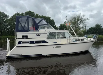 wit motorjacht in water bij bomen