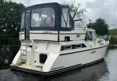 wit motorjacht met kajuit en bimini op water