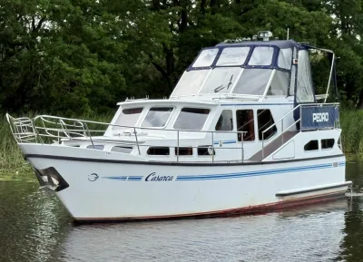witte kajuitmotorboot op rustig water