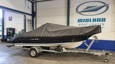 boot met afdekzeil op trailer in loods