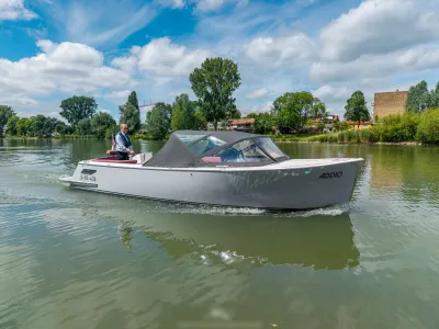 cabinsloep op rivier onder bewolkte lucht