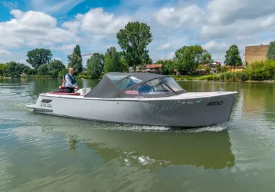 cabinsloep op rivier onder bewolkte lucht