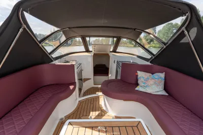 interieur van cabinsloep met zitbanken en teakdek