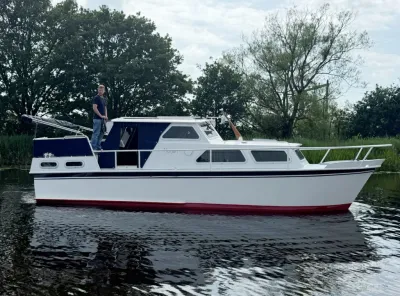 motorkruiser op water met bomen op achtergrond