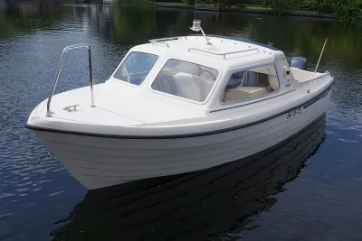 witte kajuitboot op rustig water