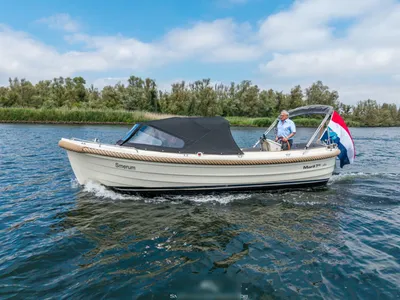 Witte sloep varend met bemanning