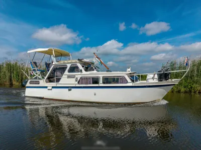 witte motorboot langs riet in zonnige lucht