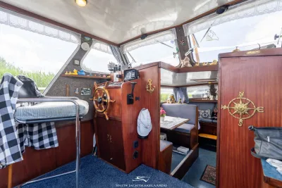 interieur van houten stuurhut met zithoek