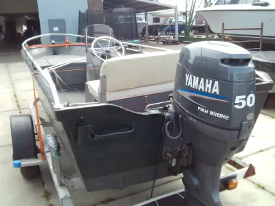 kleine visboot op trailer met buitenboordmotor