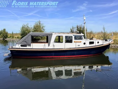 witte motorboot afgemeerd op rustig water