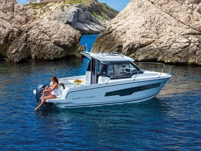 motorboot in kalm blauw water bij rotsen